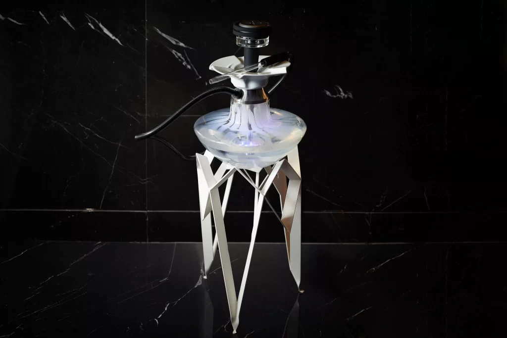 A silver shisha on a black floor