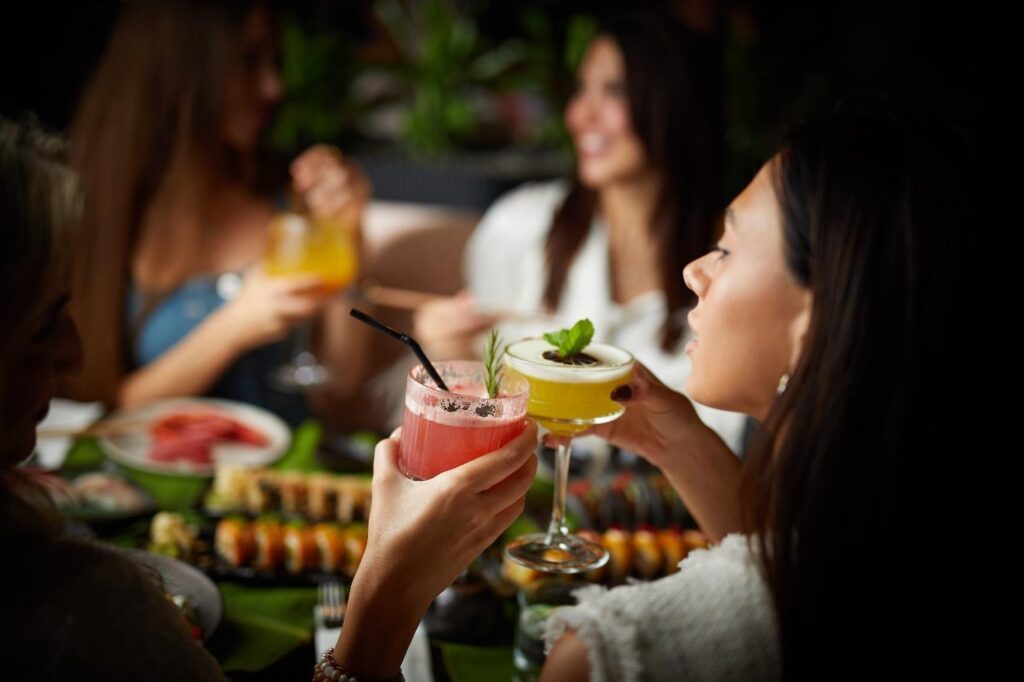 Women having drinks with each other and food on the table
