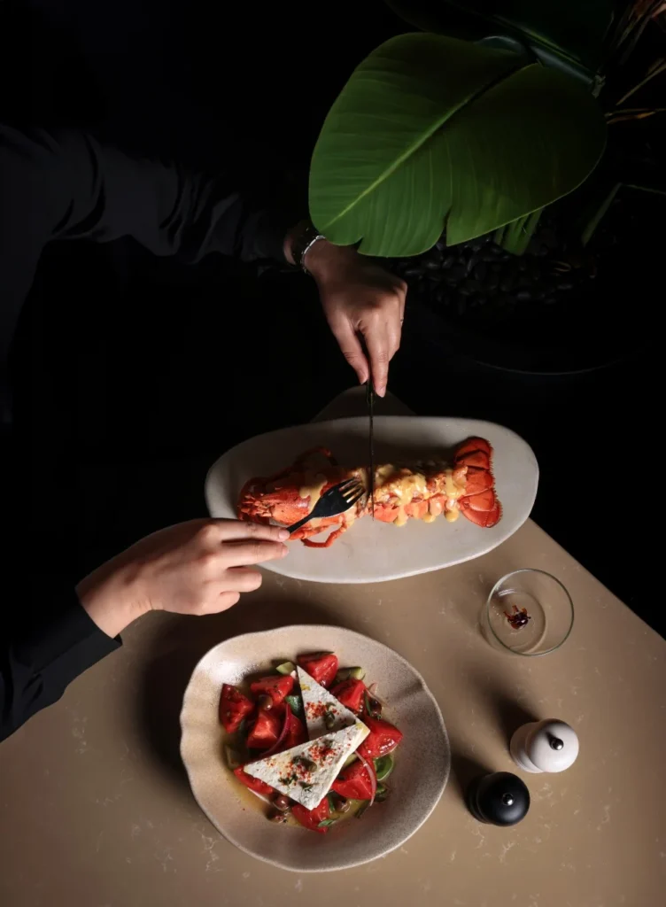a pair of hands cutting portion of meal with fork and knife