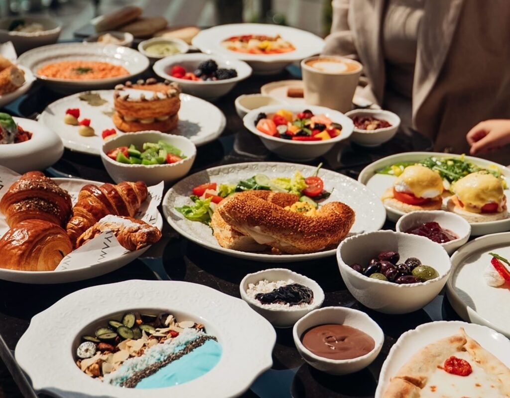 A rich brunch spread with pastries, eggs, fruits, and coffee on a cozy table.