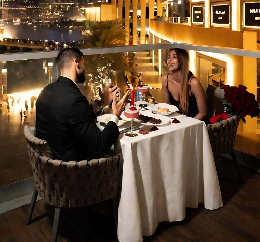 Dubai after dark food guide romantic rooftop dining couple enjoying luxury dinner with Burj Khalifa night view in Downtown Dubai restaurant terrace